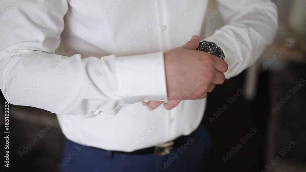 man dresses a watch on his hand man dresses a watch on his hand