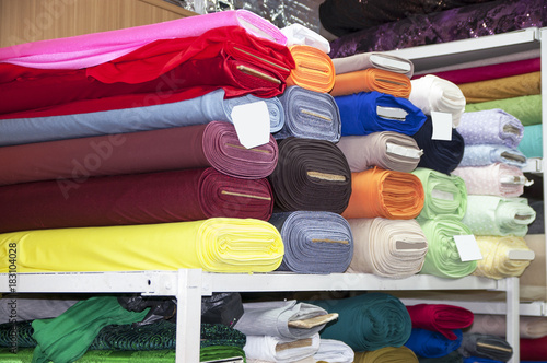 Rolls of cotton fabric on the shelf