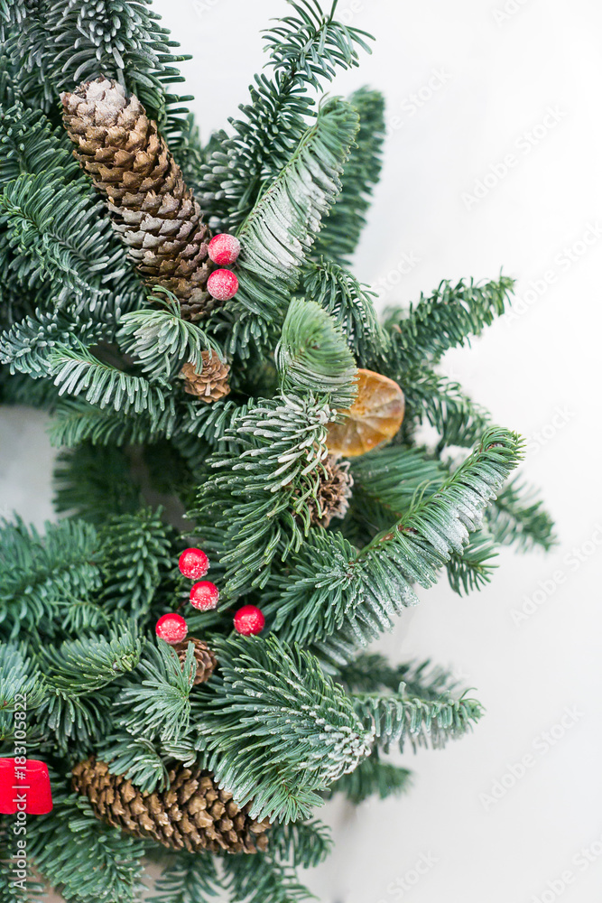 decoration, design, christmas concept. close up of fresh green wreath weaved of conifer branches, and among them there are bright red berries that richly embellish decoration, design, christmas concept. close up of fresh green wreath weaved of conifer branches, and among them there are bright red berries that richly embellish