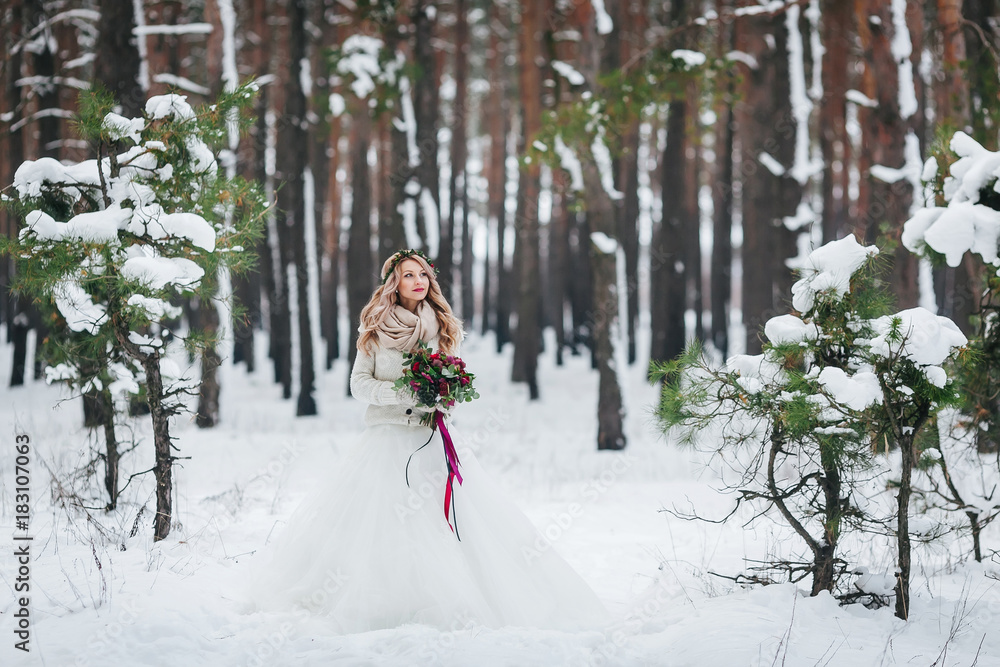 Beautiful bride posing with bouquet in snowy forest. Winter wedding. Artwork. Beautiful bride posing with bouquet in snowy forest. Winter wedding. Artwork.