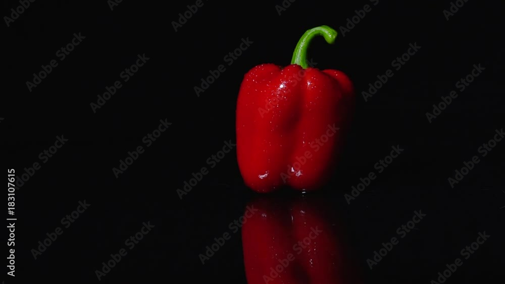 Ripe red peppers rotating on black background. Close-up, slow motion. The movement of the light. Changing lighting Ripe red peppers rotating on black background. Close-up, slow motion. The movement of the light. Changing lighting
