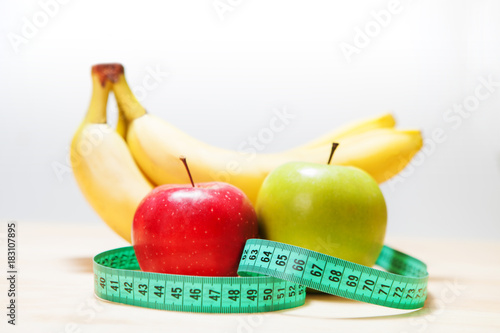 Fototapeta Naklejka Na Ścianę i Meble -  Healthy diet, fitness and weight loss concept, scales, measuring tape, fruits, vegetables on the table.