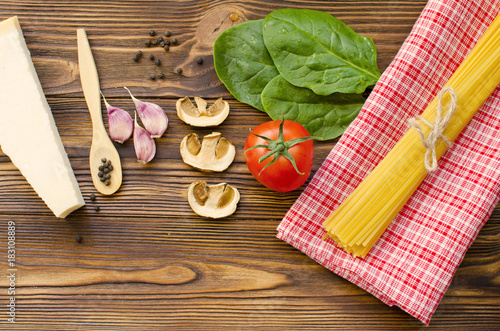 Italian food ingredients  pasta  tomato  spinach  pepper  porcini on wooden background