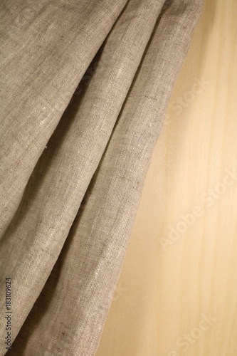 Linen unpainted fabric with folds on the background of wood