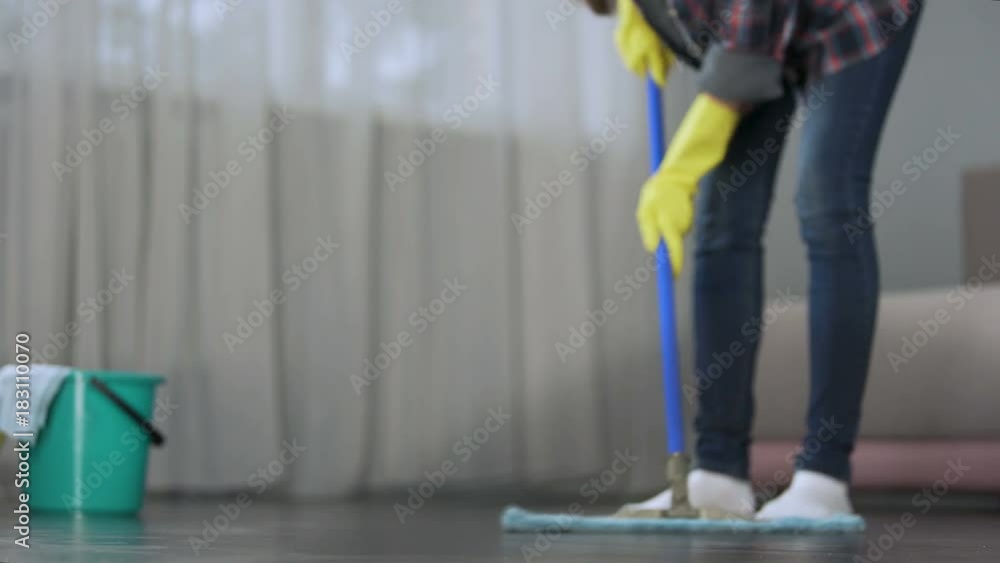 Maid carefully washing floor of hotel room before arrival of guests, cleaning Maid carefully washing floor of hotel room before arrival of guests, cleaning