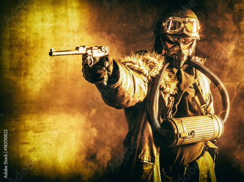 Futuristic nazi soldier in fire and smoke gas mask and steel helmet with luger pistol handgun photo