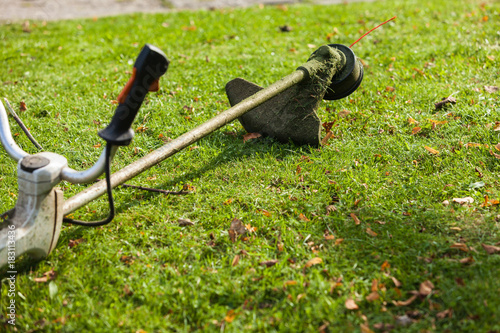 Mower brushcutter on green grass photo