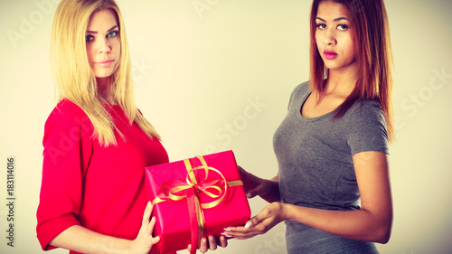 Two beautiful women with red gift box