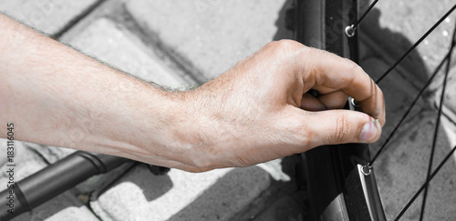 Panorama of side view of Man pumping bicycle tyre outdoors, close-up of hands