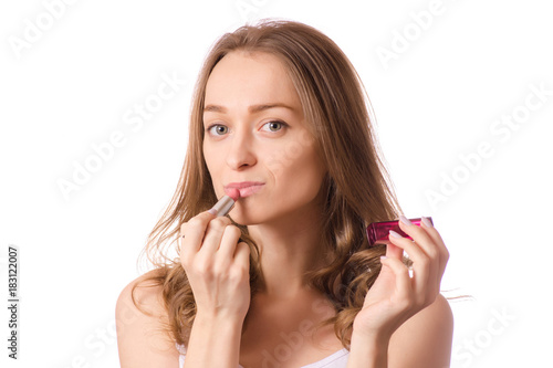Beautiful young woman wearing lipstick in hand