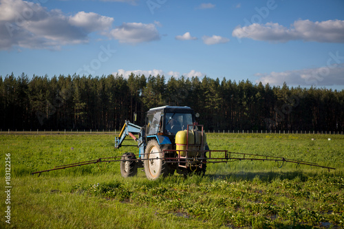 Agrikultura tractor cultivates the soil on the field photo