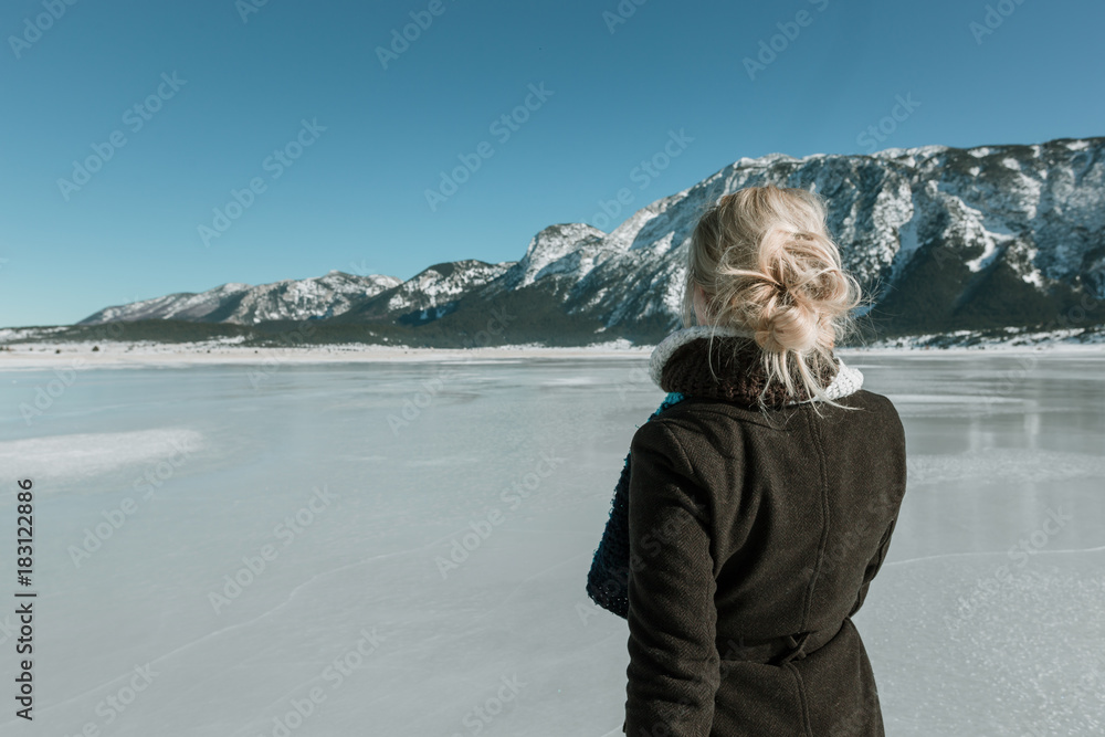rear view of woman looking at mountain and frozen lake rear view of woman looking at mountain and frozen lake