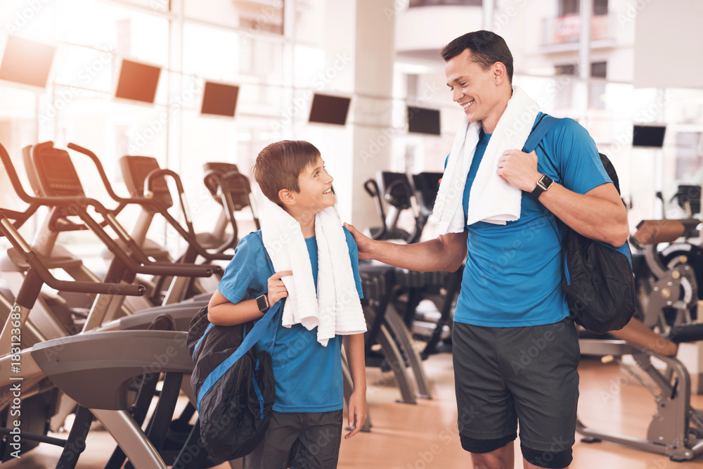Dad and son in the same clothes in gym. Father and son lead a healthy lifestyle. Dad and son in the same clothes in gym. Father and son lead a healthy lifestyle.