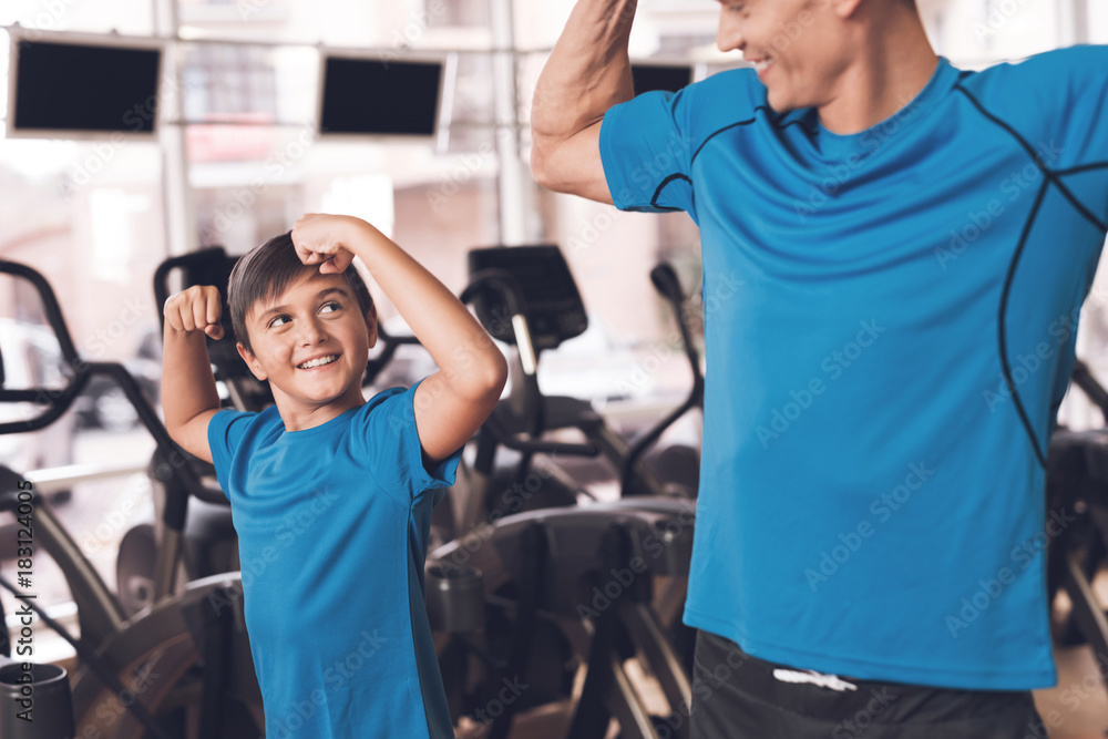 Dad and son in the same clothes in gym. Father and son lead a healthy lifestyle. - obrazy, fototapety, plakaty 