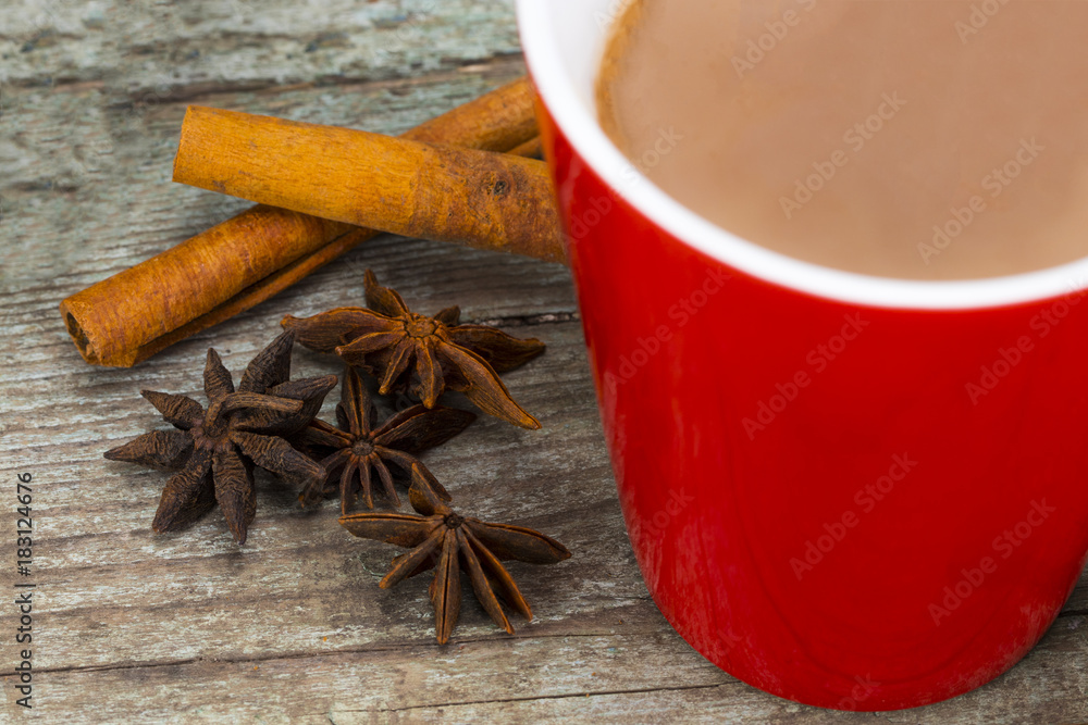 Red Cup of hot Chocolate drink with and cinnamon on wooden background. Winter time. Holiday concept, Selective focus Red Cup of hot Chocolate drink with and cinnamon on wooden background. Winter time. Holiday concept, Selective focus