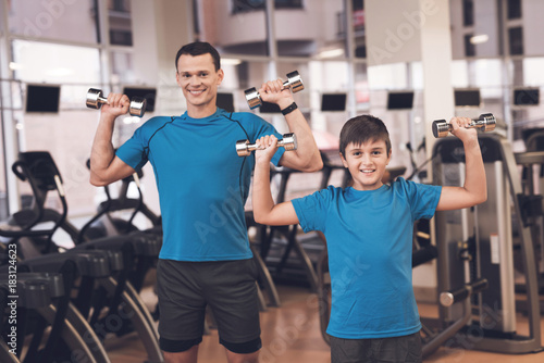 Dad and son in the same clothes in gym. Father and son lead a healthy lifestyle.