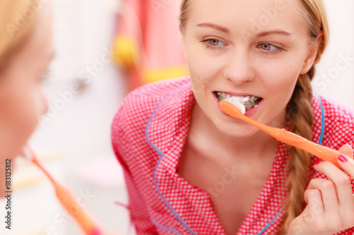 Woman brushing cleaning teeth in bathroom