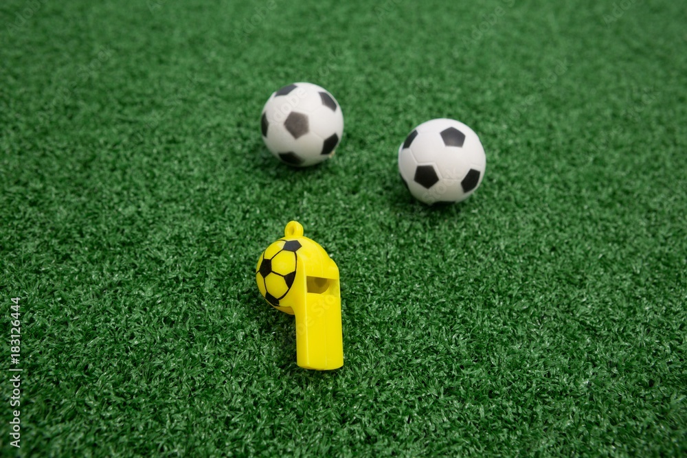 Whistle and footballs on artificial grass Whistle and footballs on artificial grass