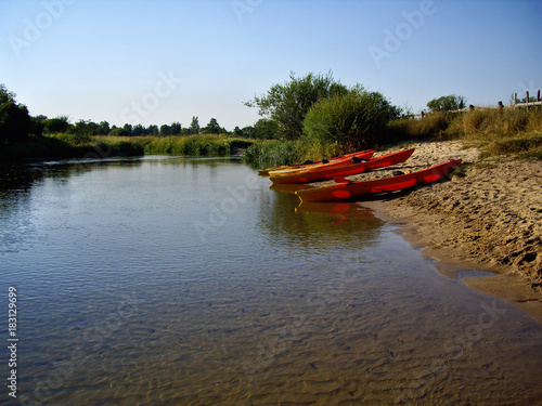 czerwone kajaki na piaszczystym brzegu rzeki