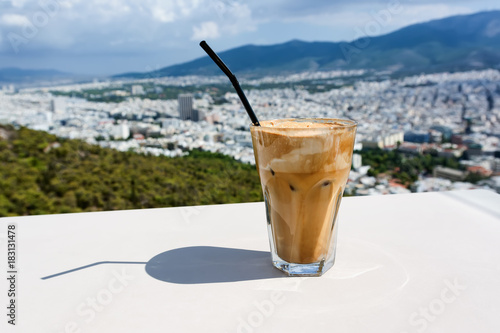 Ice frappe coffee and view of town of Athens for background. photo