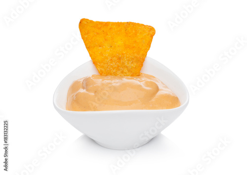 Glass container with cheese dip and nachos chips