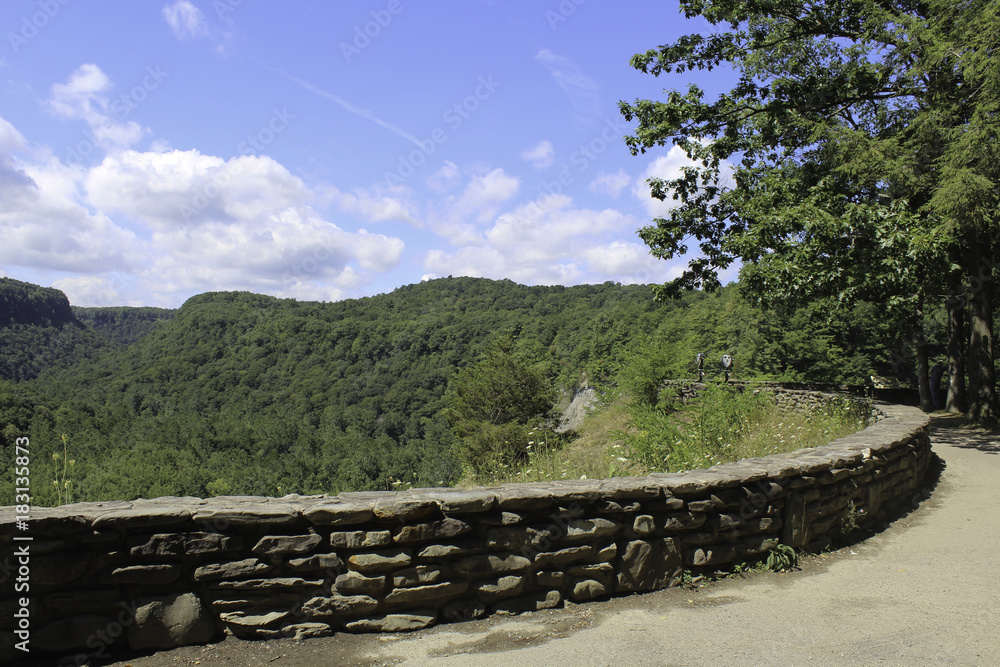 Stone wall walkway overlooking the forest and river at Letchworth State Park 