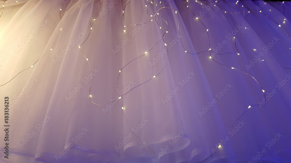 Illuminated LED icicle light against sheer fabric background - obrazy, fototapety, plakaty 