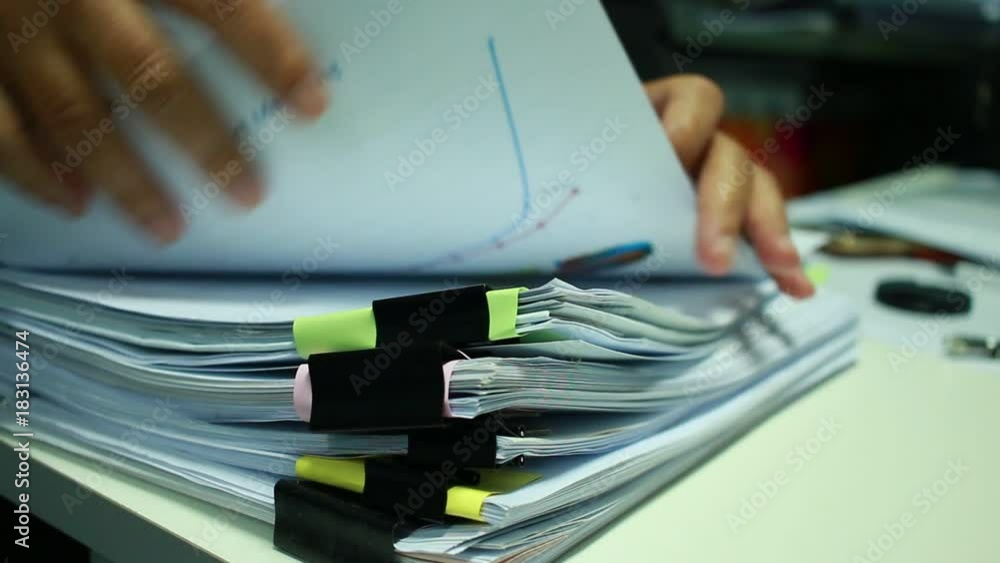 Businesswoman hands working on Stacks of documents files for finance in office. Business report papers or Piles of unfinished document achieves with black clip paper. Concept of Business Annual Report Businesswoman hands working on Stacks of documents files for finance in office. Business report papers or Piles of unfinished document achieves with black clip paper. Concept of Business Annual Report