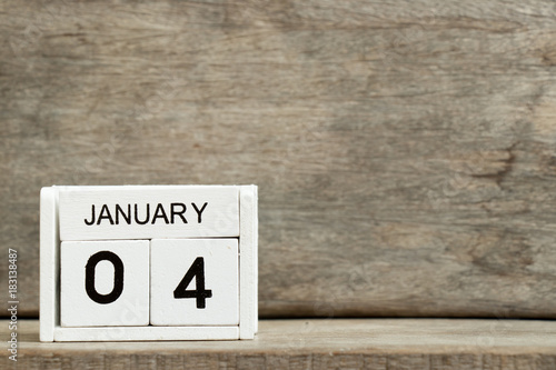 White block calendar present date 4 and month january on wood background