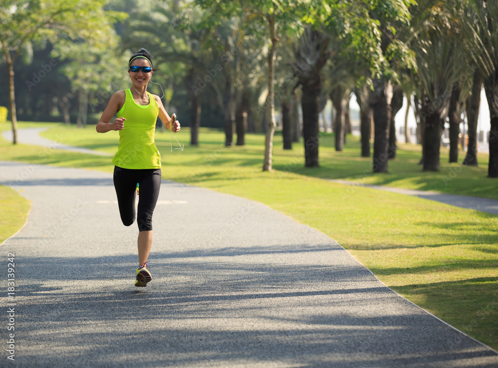 Young fitness woman running at tropical park Young fitness woman running at tropical park