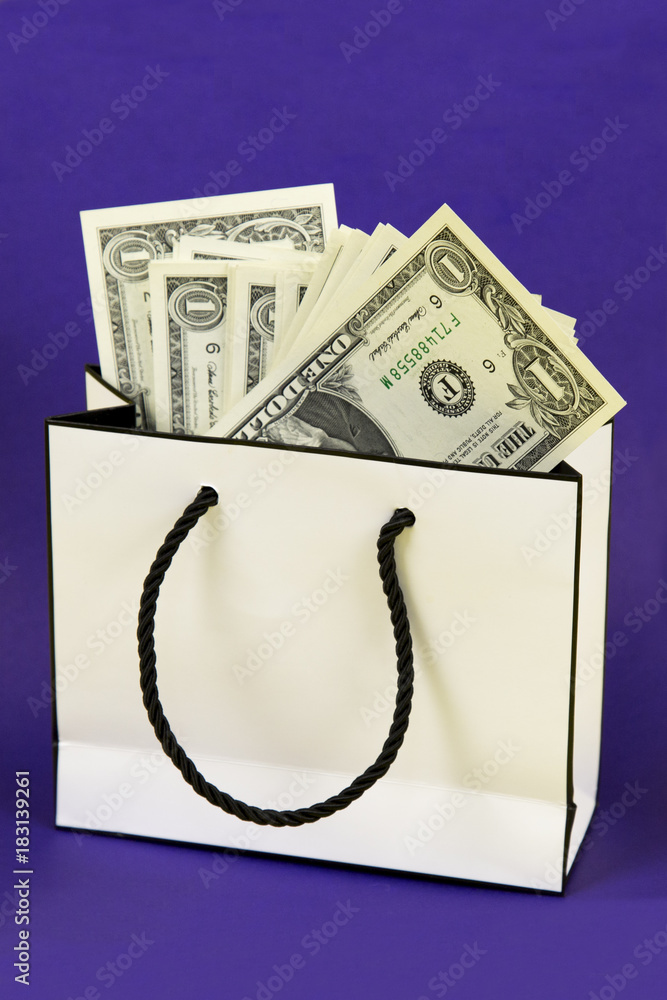 Gift bag with money. Paper money in a beautiful gift box on a bright violet blue background Gift bag with money. Paper money in a beautiful gift box on a bright violet blue background