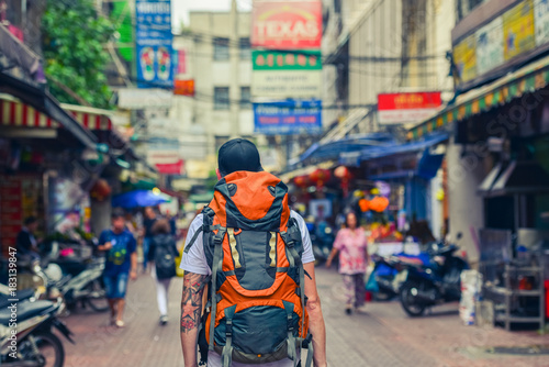 Backpacker man walking in the street of Asia. Bangkok, Thailand. photo
