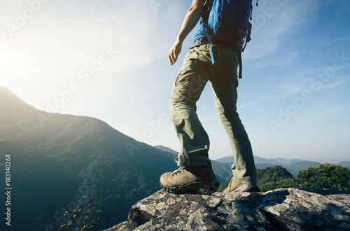 successful female backpacker enjoy the view cliff's edge photo