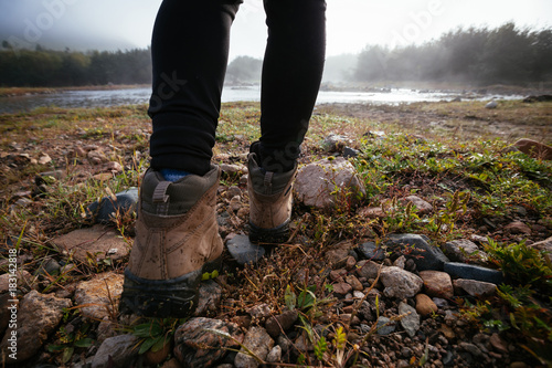 woman hiker legs hiking on the morning riverside