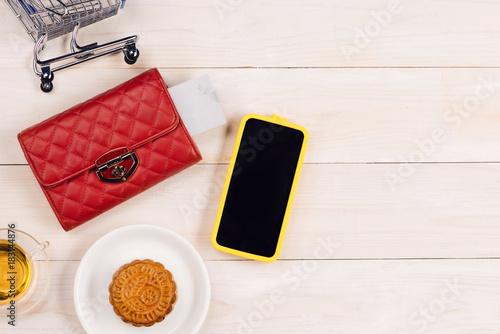 Wallet with credit card, on table with cup of tea and dessert. Top view with copy space