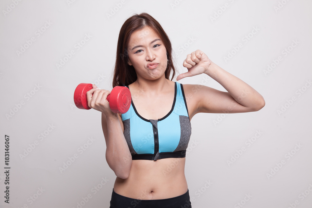 Beautiful Asian healthy girl thumbs down with dumbbell. Beautiful Asian healthy girl thumbs down with dumbbell.