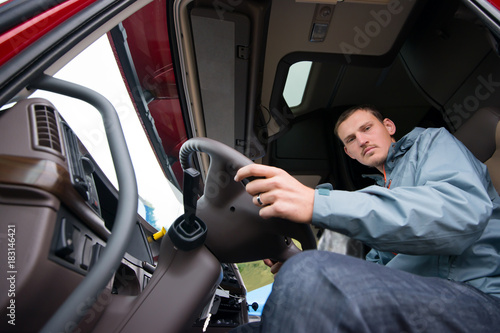 Truck driver sitting in cab of modern semi truck