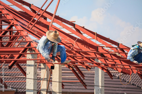 welder workers installing steel frame structure of the house roof at building construction site © Piman Khrutmuang