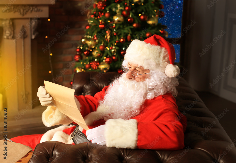 Portrait of happy Santa Claus sitting at his room at home near Christmas tree and reading Christmas letter or wish list. Portrait of happy Santa Claus sitting at his room at home near Christmas tree and reading Christmas letter or wish list.