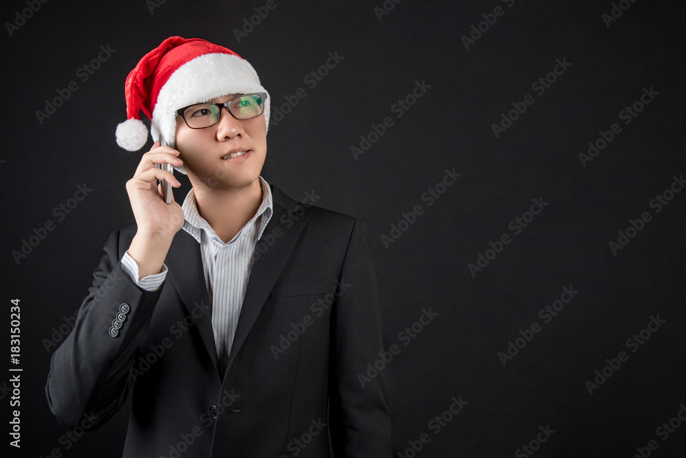 Young Asian businessman with santa hat using smartphone Young Asian businessman with santa hat using smartphone