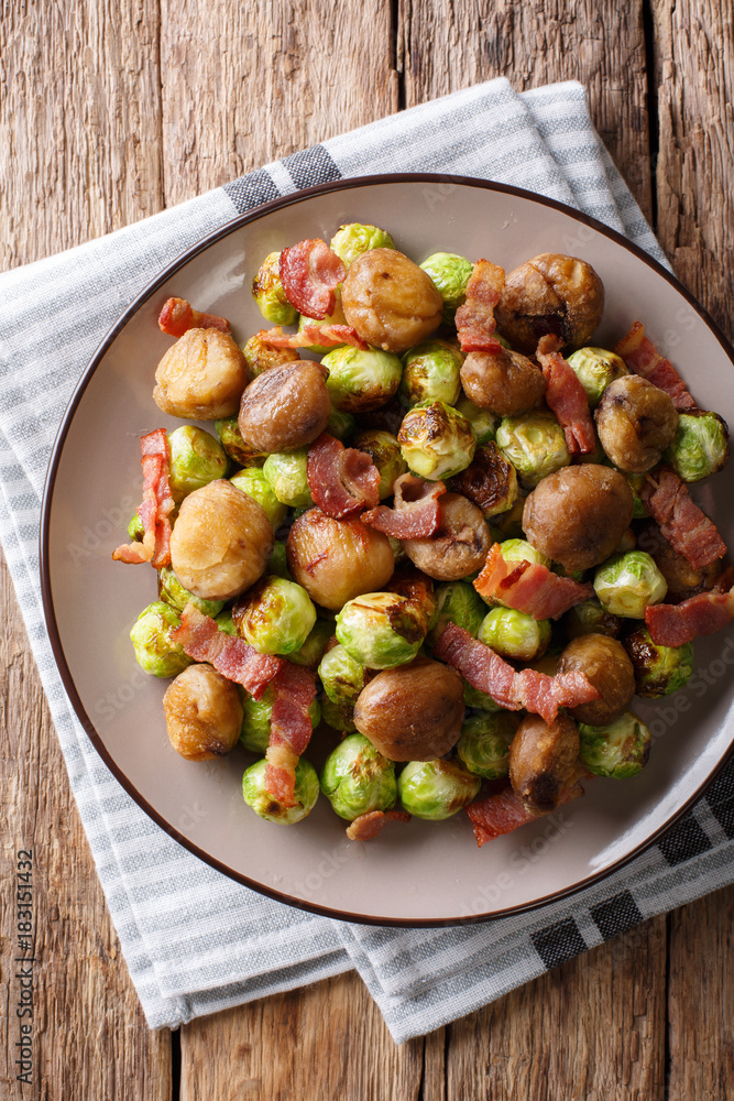 Delicious appetizer: roasted chestnuts, Brussels sprouts and bacon close-up. Vertical top view Delicious appetizer: roasted chestnuts, Brussels sprouts and bacon close-up. Vertical top view