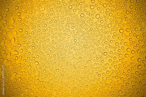 Water drops on yellow glass, Rain droplets on glass background.