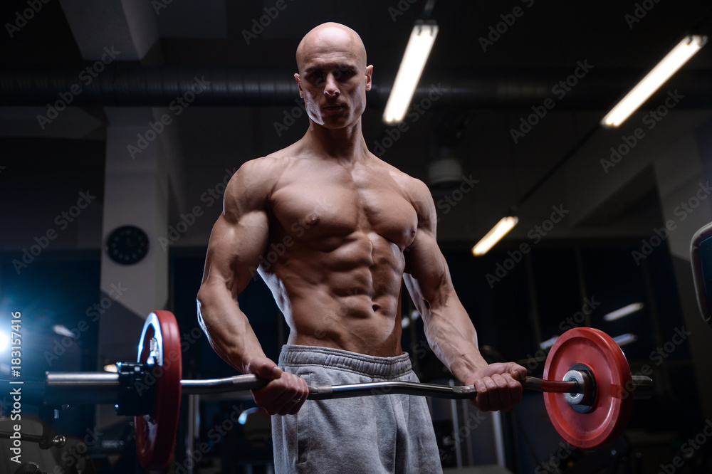 Brutal strong bodybuilder athletic men pumping up muscles with dumbbells Brutal strong bodybuilder athletic men pumping up muscles with dumbbells