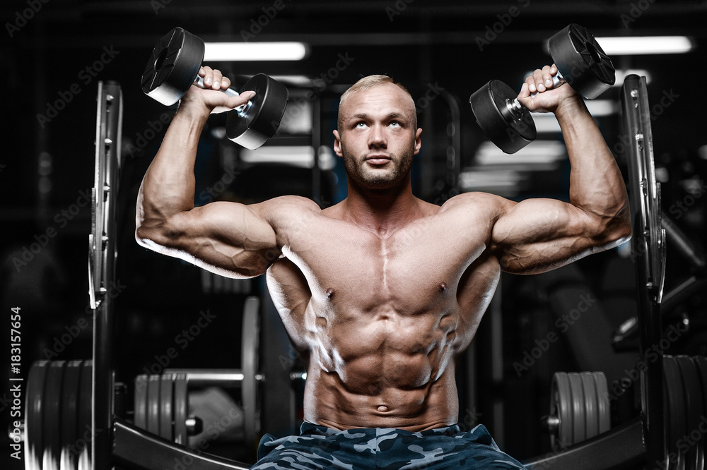 Brutal strong bodybuilder athletic men pumping up muscles with dumbbells. Brutal strong bodybuilder athletic men pumping up muscles with dumbbells.