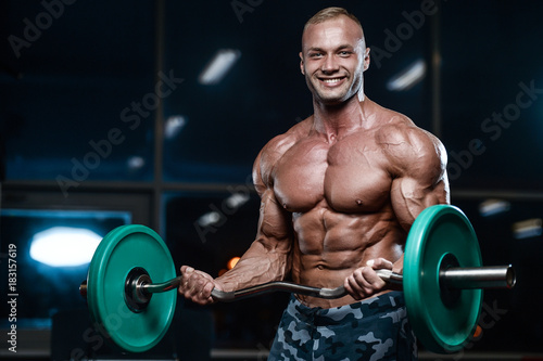 Brutal strong bodybuilder athletic men pumping up muscles with dumbbells. © antondotsenko
