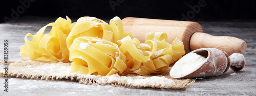 Картината върху платно Making homemade pasta linguine on rustic kitchen table with flour, rolling pin and pasta