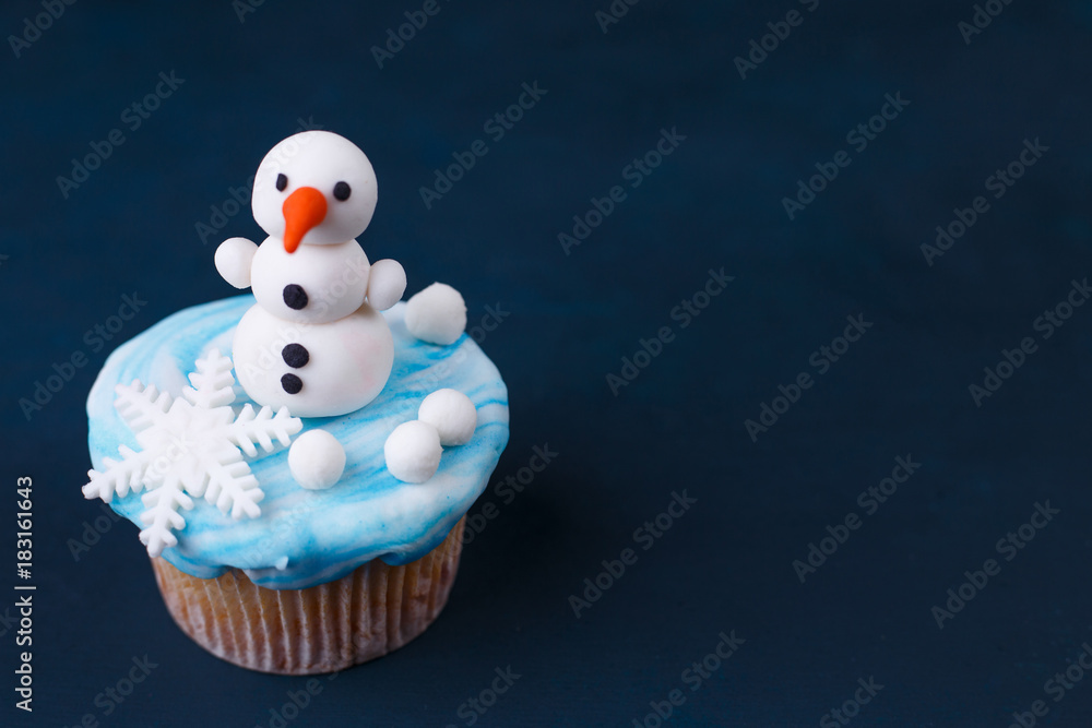 Φωτογραφία Funny homemade New Year party cupcake with snowman decoration made of confectionery mastic, free space for text