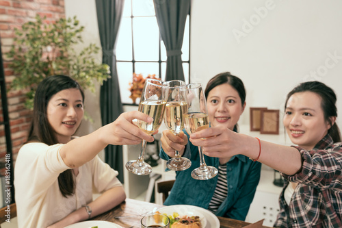 women hands holding glasses and toasting up
