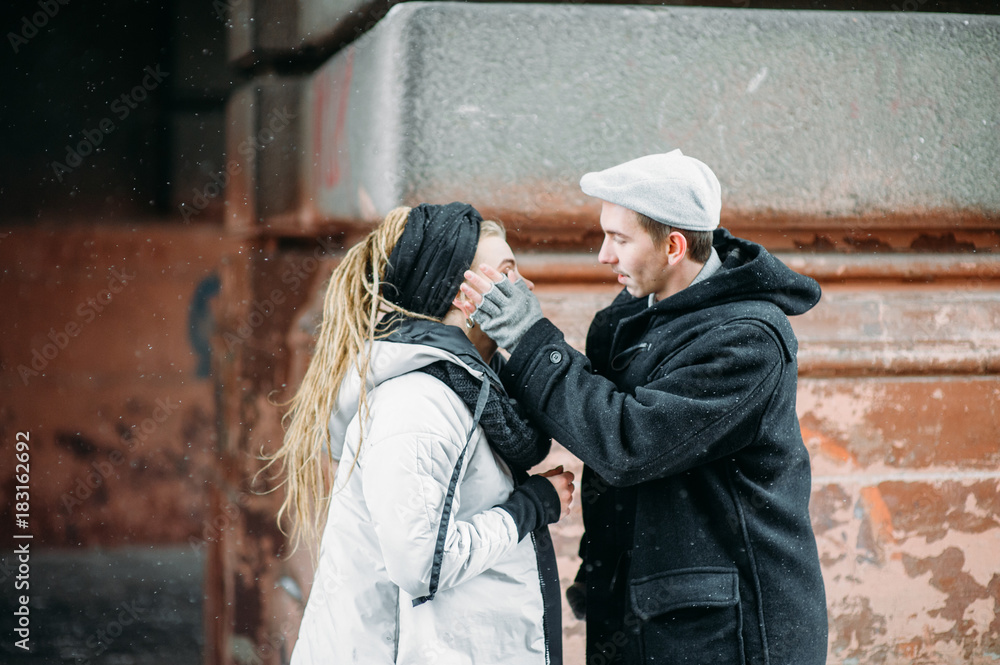 Couple has fun and laughs. kiss. Young hipster couple hugging each other in winter park. Winter love story, a beautiful stylish young couple. Winter fashion concept with boyfriend and girlfriend. Couple has fun and laughs. kiss. Young hipster couple hugging each other in winter park. Winter love story, a beautiful stylish young couple. Winter fashion concept with boyfriend and girlfriend.