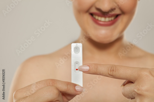 happy woman shows her negative pregnancy test